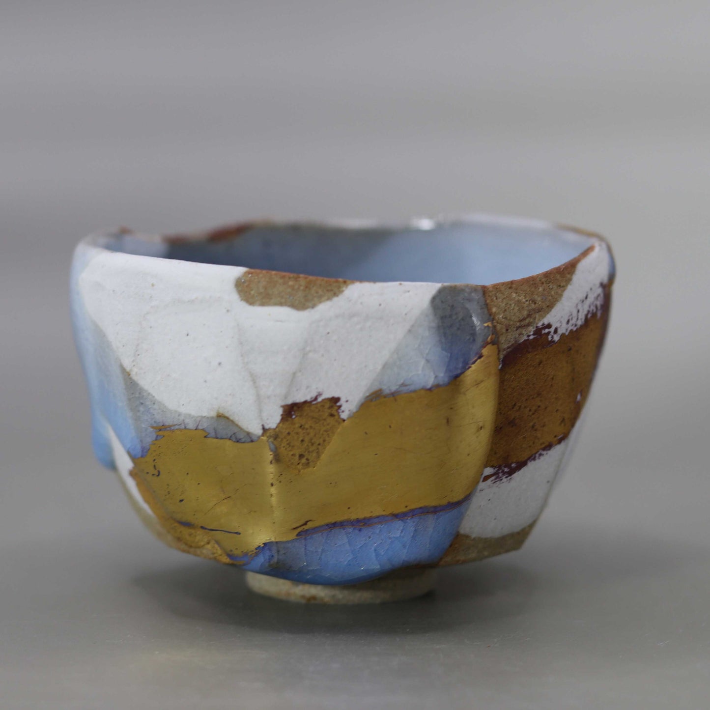 Sake cup with moon-white glaze and gold leaf by Matsubayashi Hosai