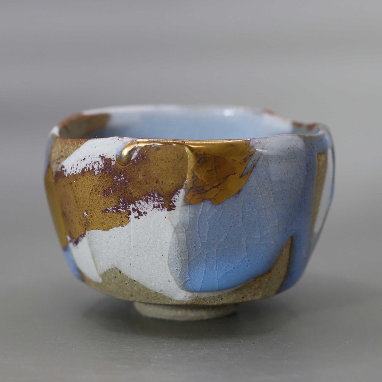 Sake cup with moon-white glaze and gold leaf by Matsubayashi Hosai