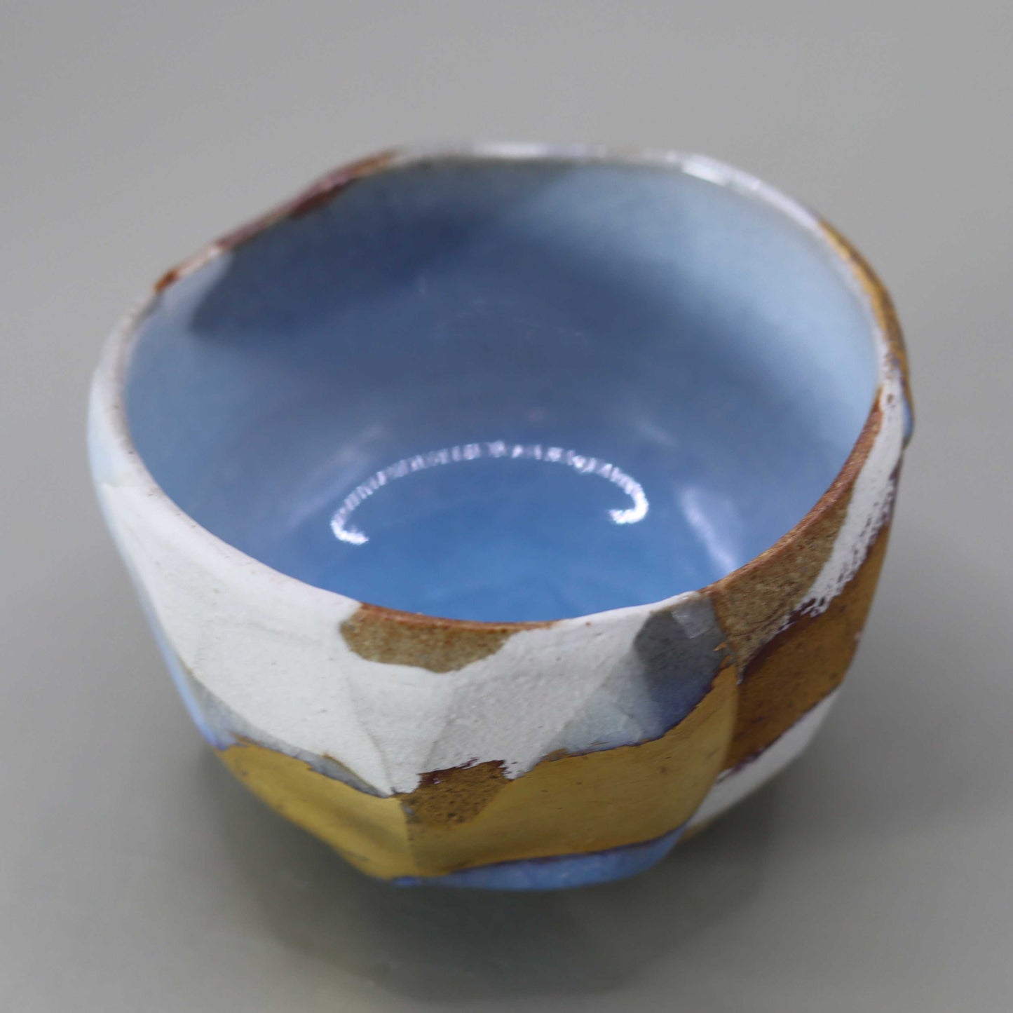 Sake cup with moon-white glaze and gold leaf by Matsubayashi Hosai