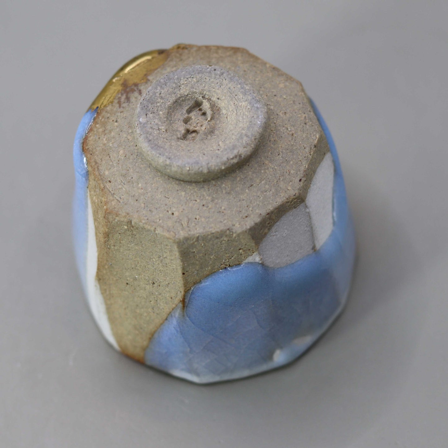 Sake cup with moon-white glaze and gold leaf by Matsubayashi Hosai
