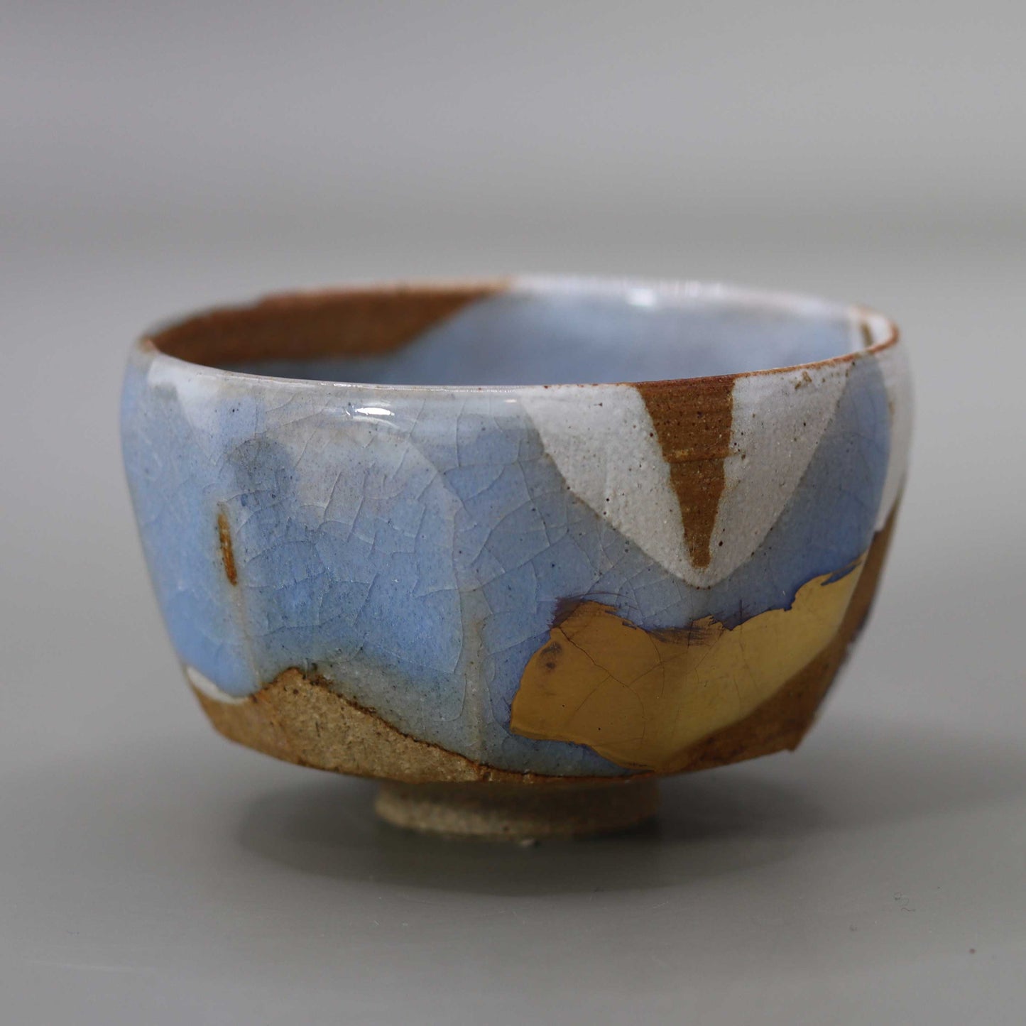 Sake cup with moon-white glaze and gold leaf by Matsubayashi Hosai