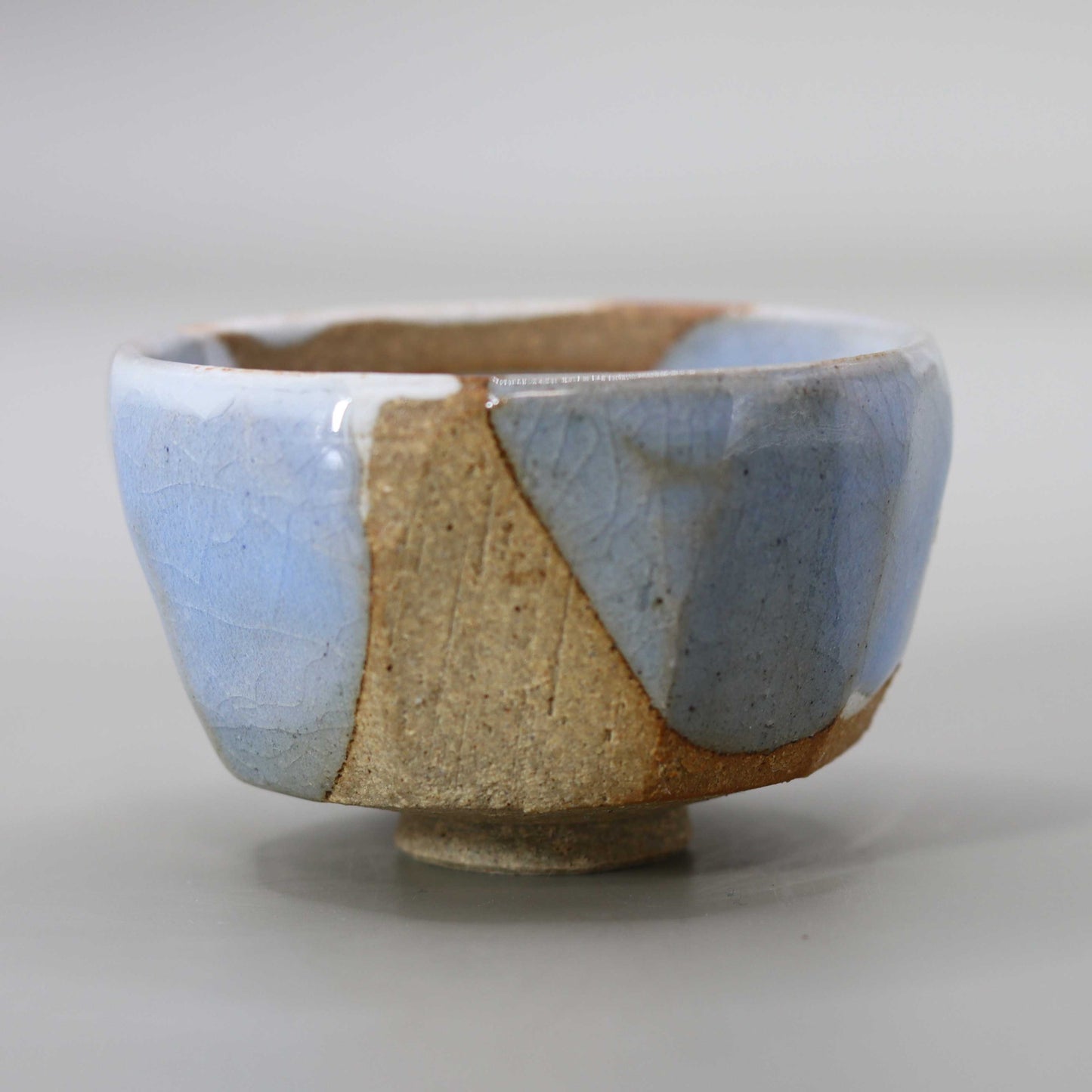 Sake cup with moon-white glaze and gold leaf by Matsubayashi Hosai