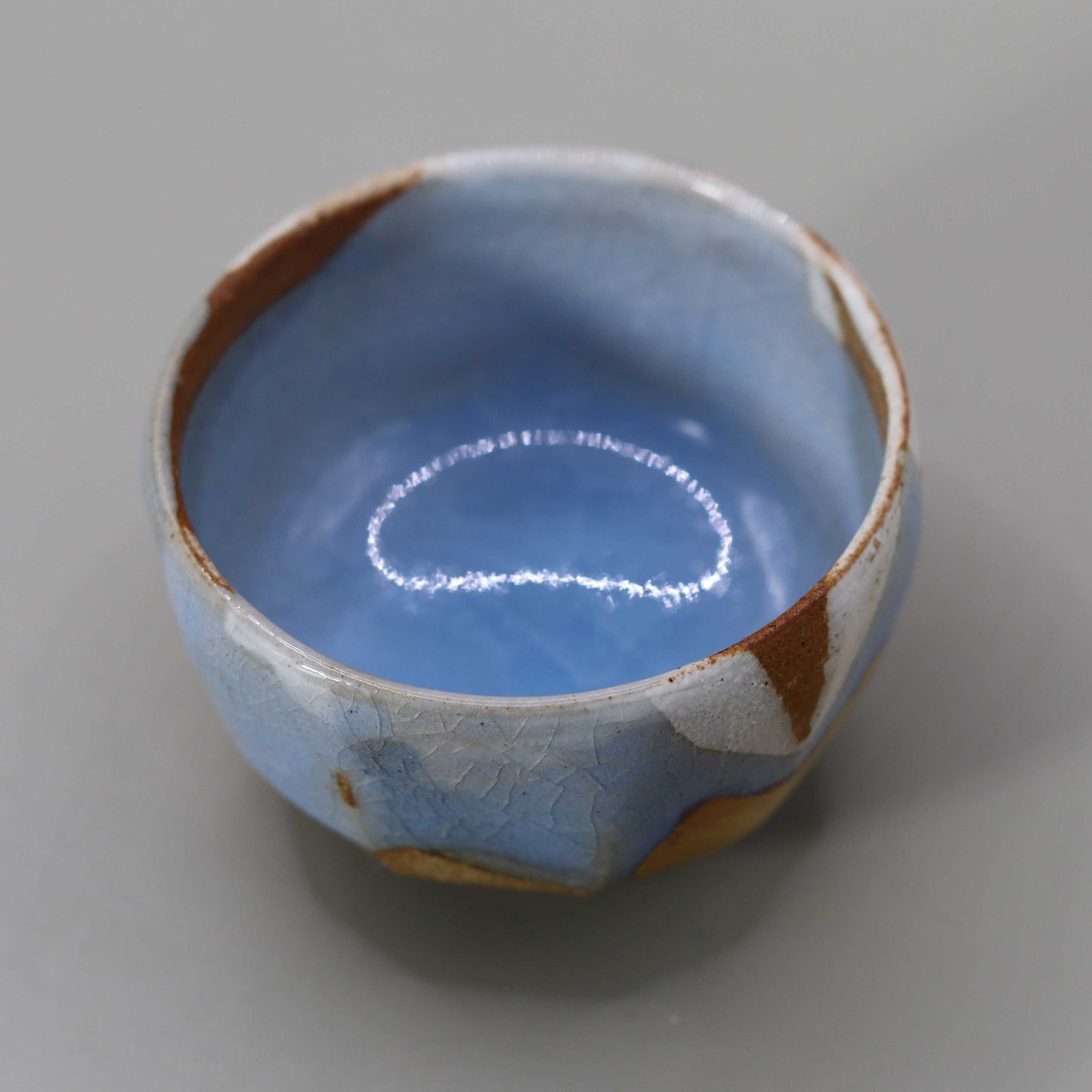 Sake cup with moon-white glaze and gold leaf by Matsubayashi Hosai