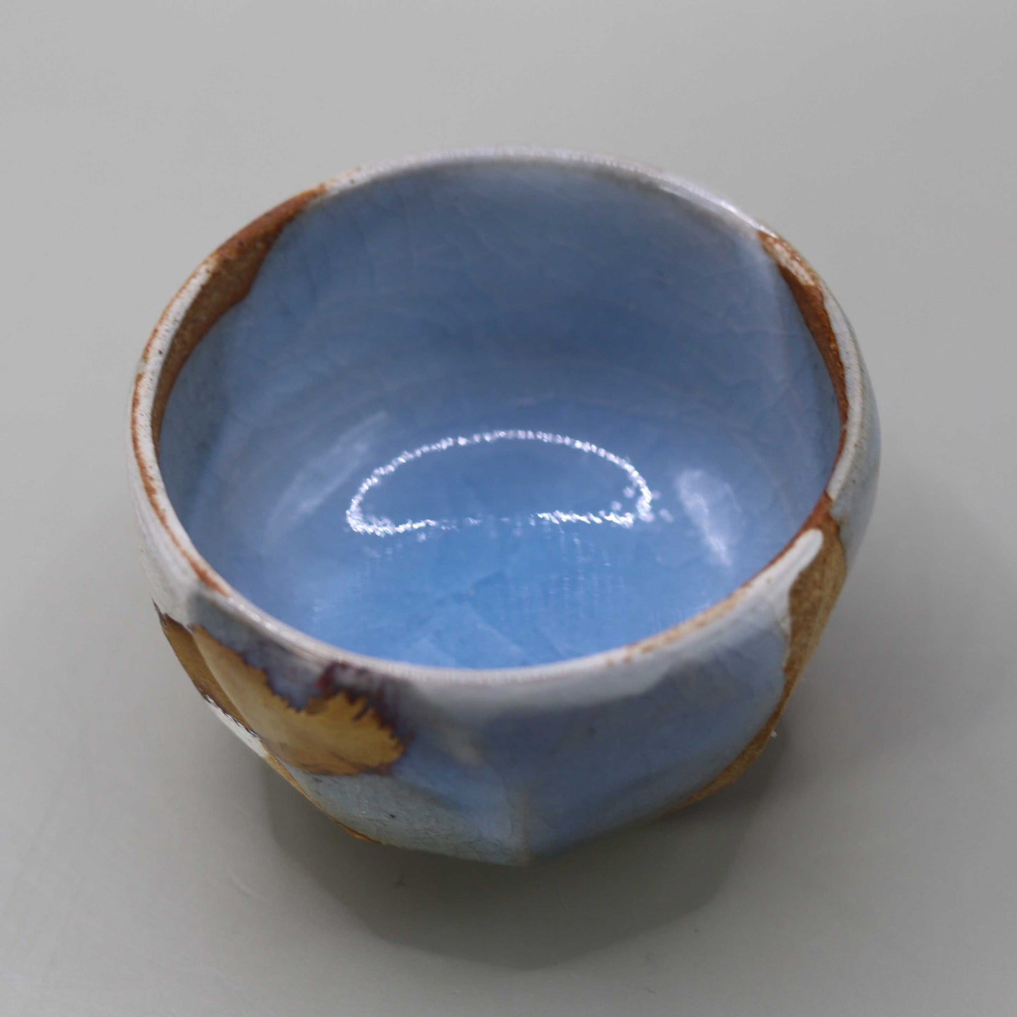 Sake cup with moon-white glaze and gold leaf by Matsubayashi Hosai