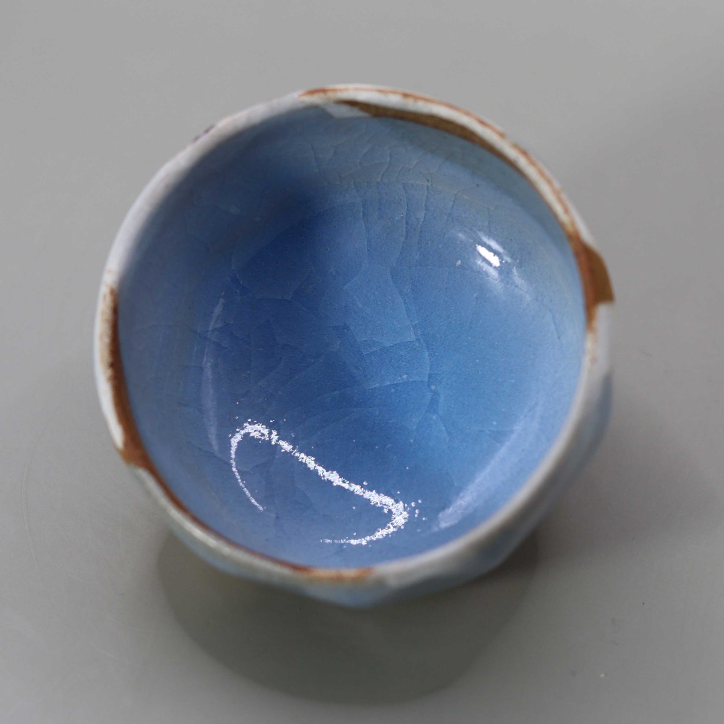 Sake cup with moon-white glaze and gold leaf by Matsubayashi Hosai