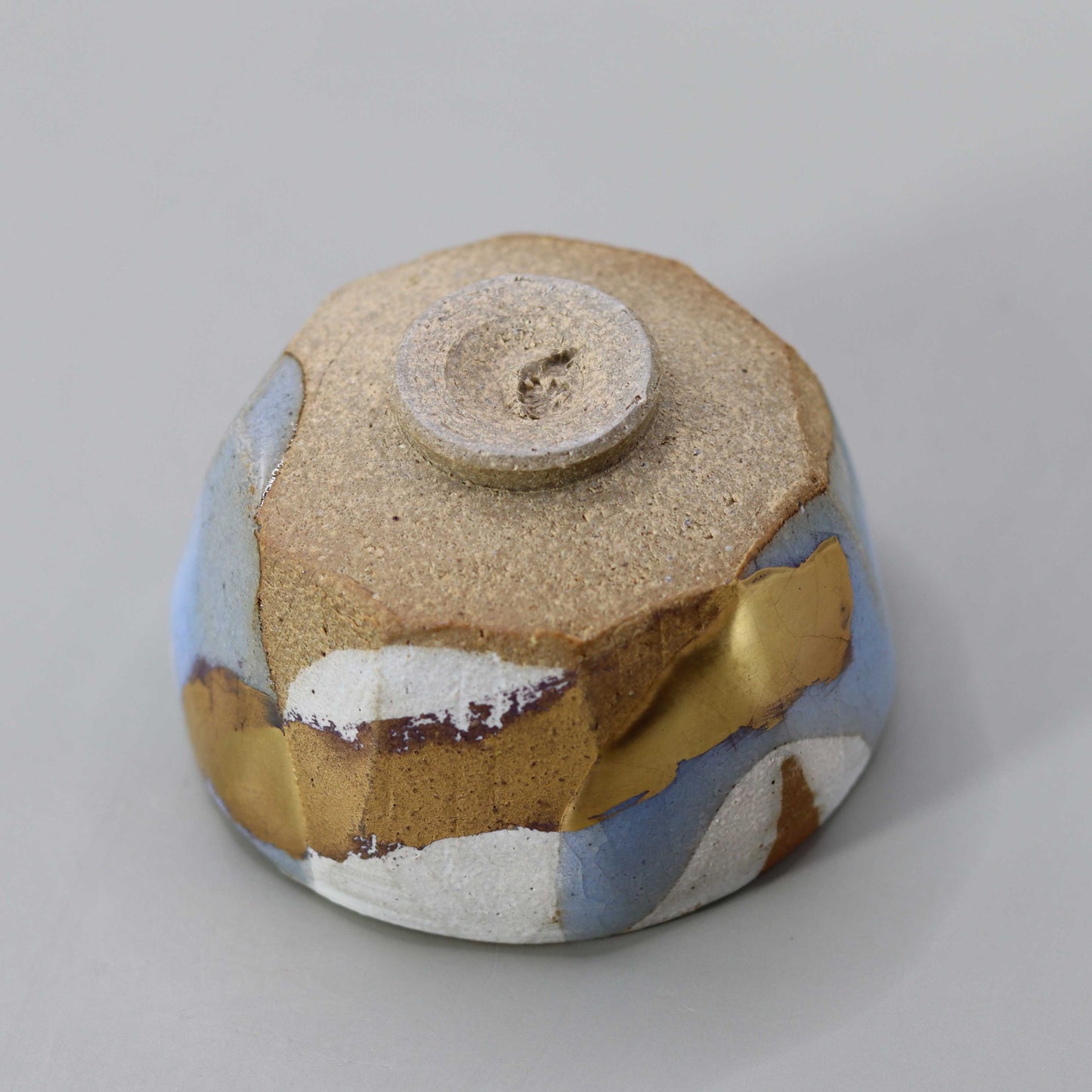 Sake cup with moon-white glaze and gold leaf by Matsubayashi Hosai