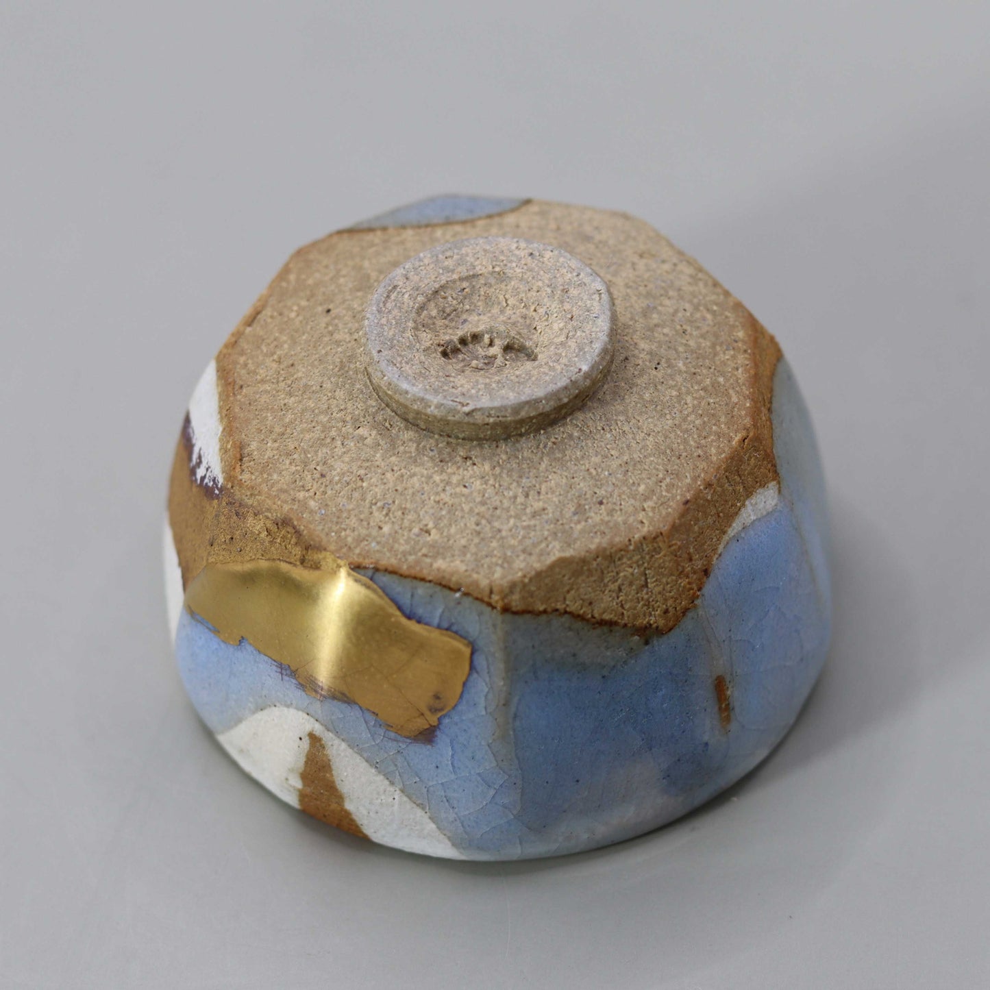 Sake cup with moon-white glaze and gold leaf by Matsubayashi Hosai