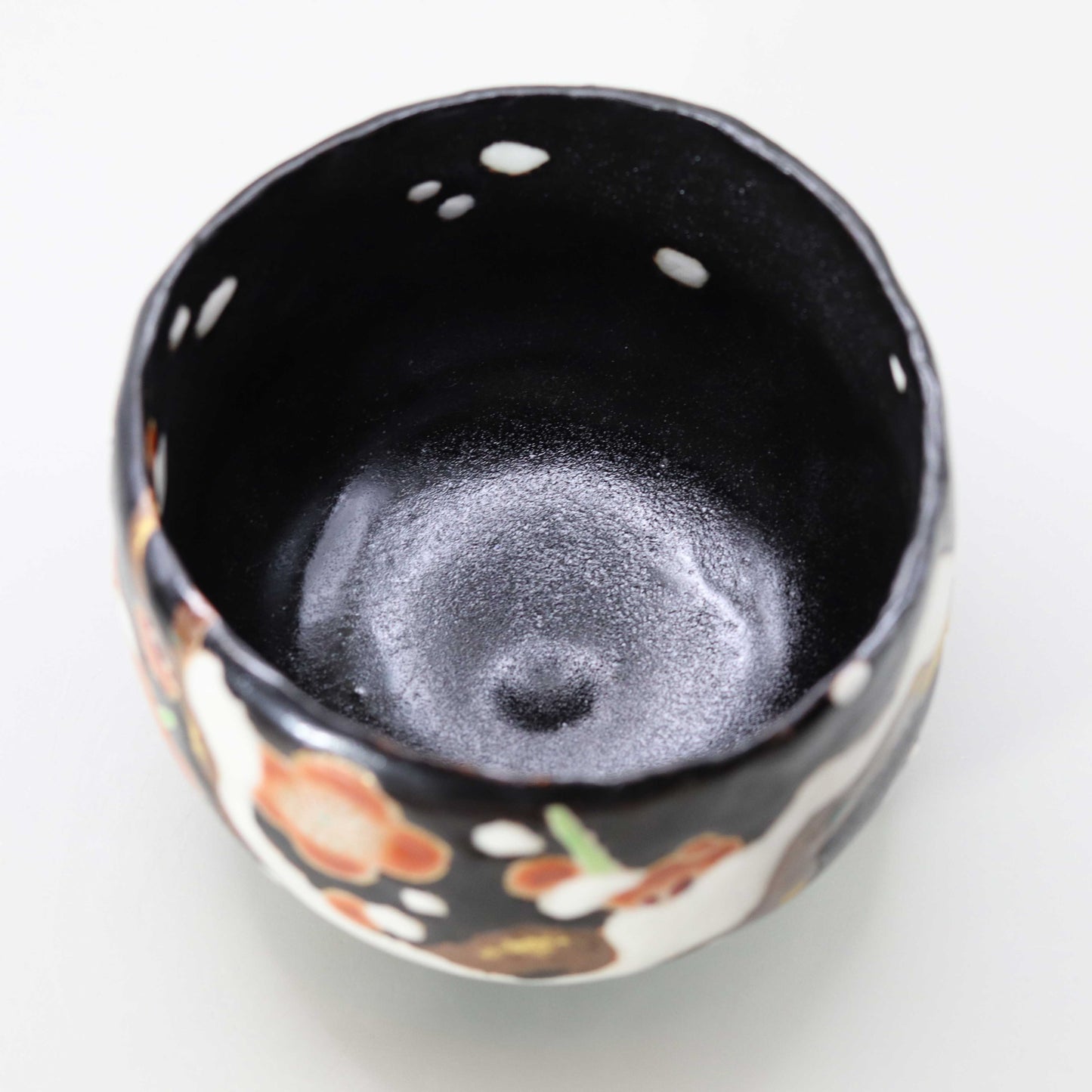 Raku tea bowl decorated with plum blossoms in the snow by Miyagawa Kosai