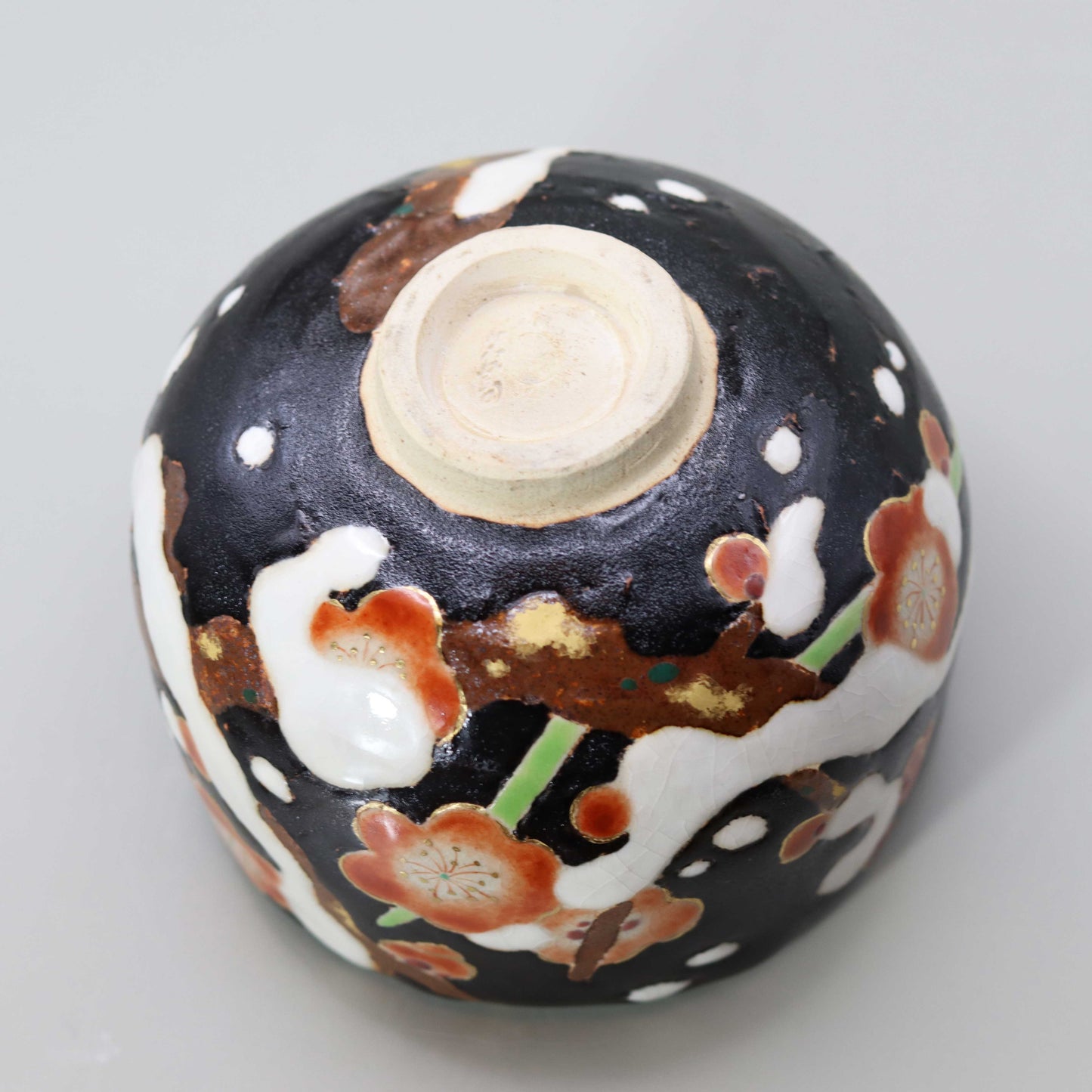 Raku tea bowl decorated with plum blossoms in the snow by Miyagawa Kosai