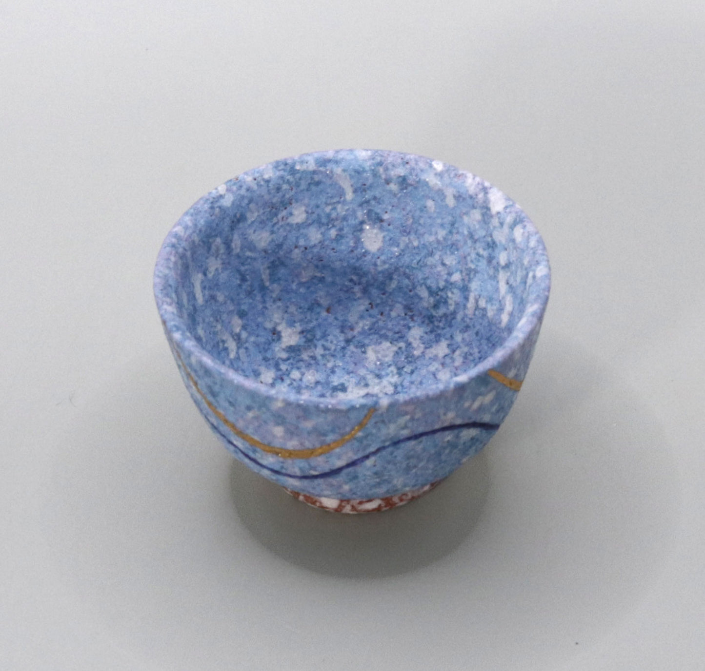 Blown mud gold and blue sake cup by Ichiji Shimizu